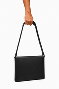 STRUCTURED LEATHER BAG 000 held by male hand — editorial view
