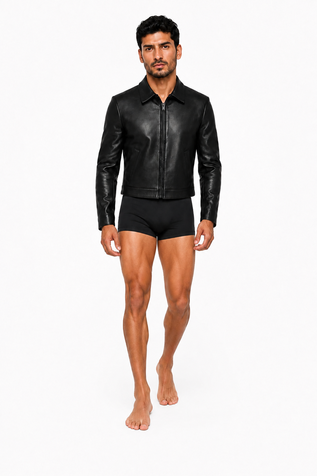 Male model wearing CROPPED LEATHER JACKET 000 with very short black lycra shorts and bare feet — front view