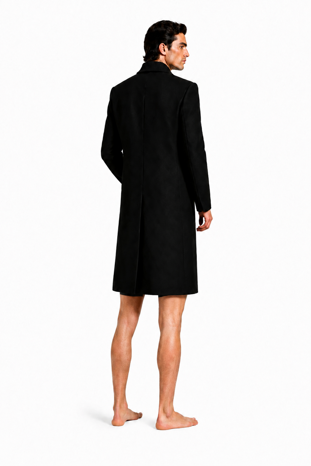 Male model wearing LONG COMMAND COAT 000 with very short black lycra shorts and bare feet — rear three-quarter view